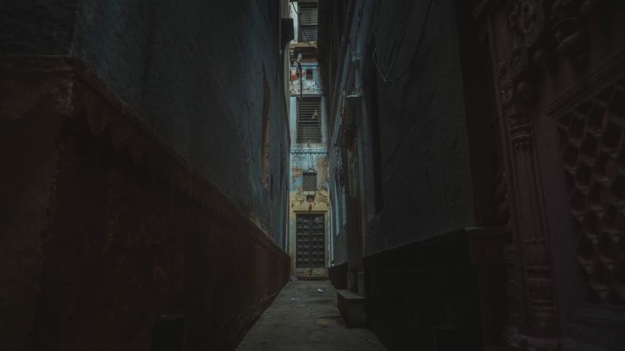 Narrow alley amidst buildings in city at night