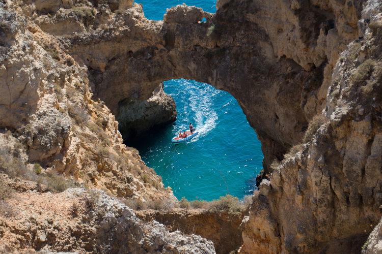 High angle view of people in boat by rock formation