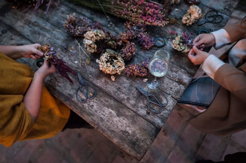 Midsection of people picking flowers while standing at table