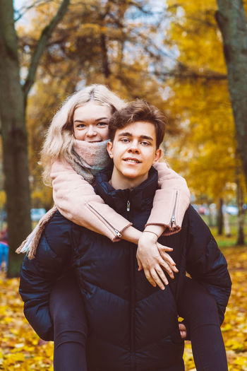 Portrait of a smiling young couple piggybacking at park