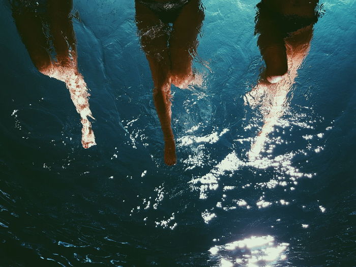 Low section of women swimming in water
