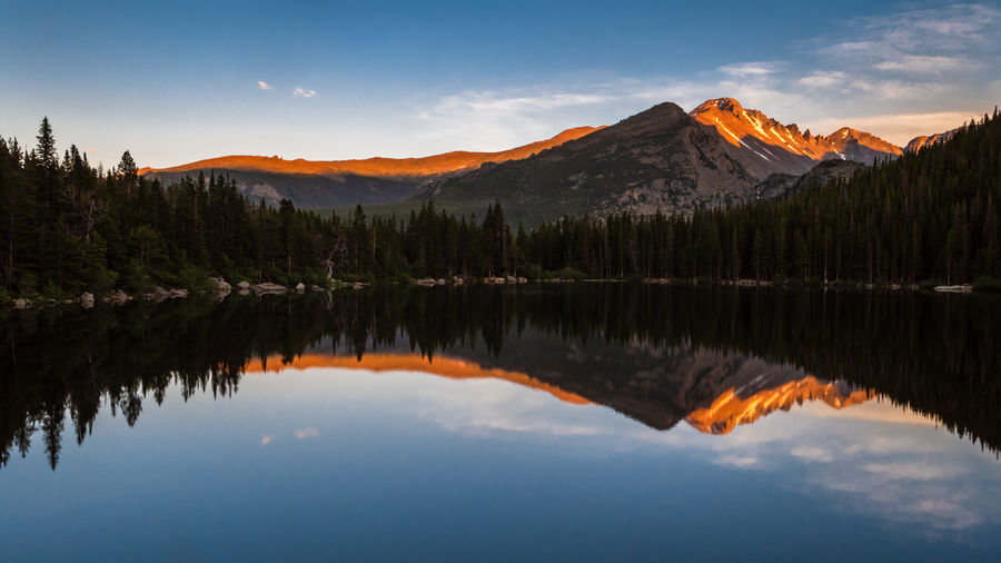 Scenic view of lake by mountains against sky