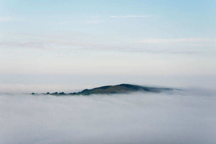 Hill appearing like an island in a sea of fog