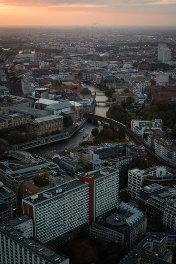High angle view of illuminated city buildings against sky during sunset