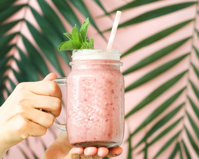 Cropped hands holding smoothie in jar