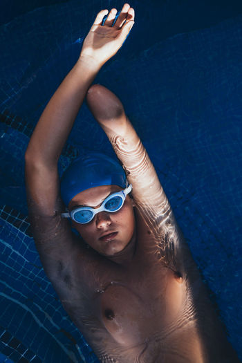 Portrait of paralympic young swimmer floatin on water in a pool