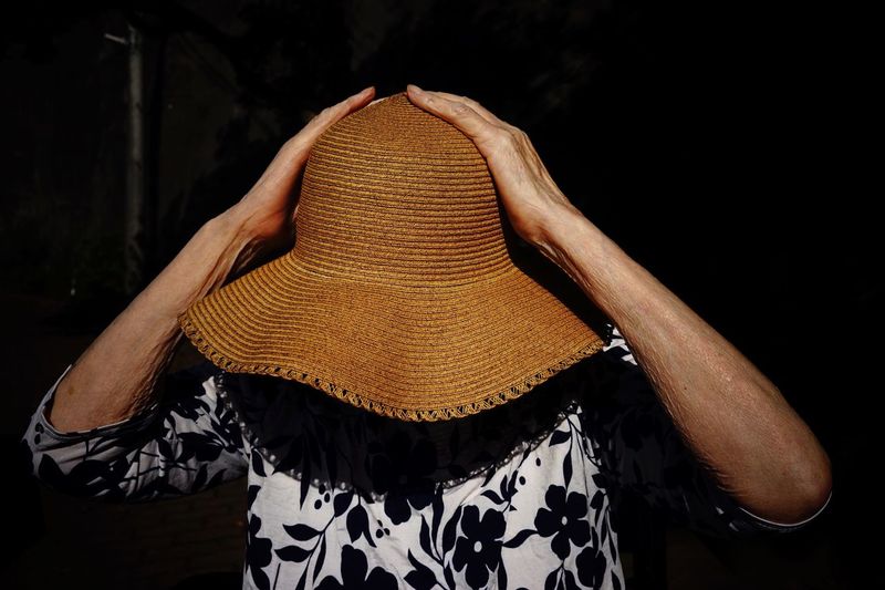 Rear view of woman standing in hat