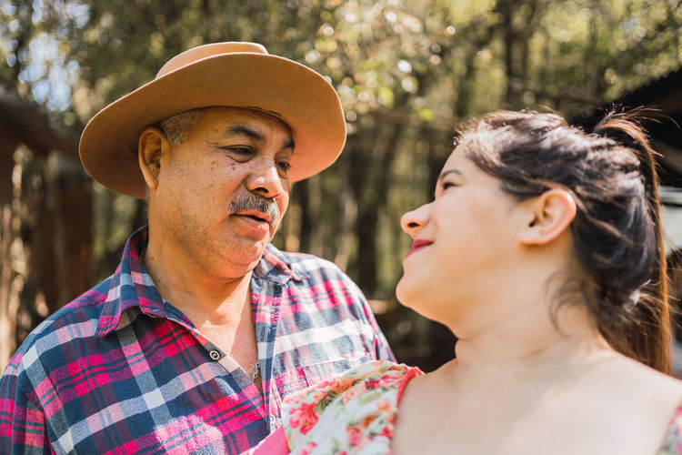 Argentinian woman in traditional skirt dancing against male partner on meadow on sunny day looking at each other