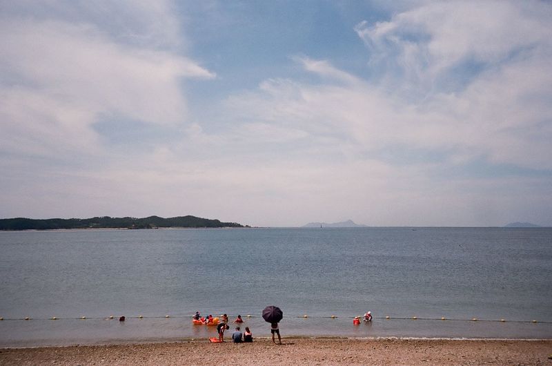 People on beach against sky