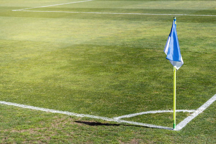 Corner flag in a soccer field on a natural grass field.