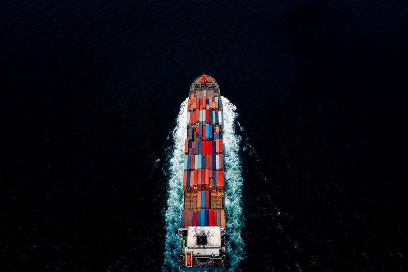 Container ship transporting large cargo logistic import export goods internationally worldwide 