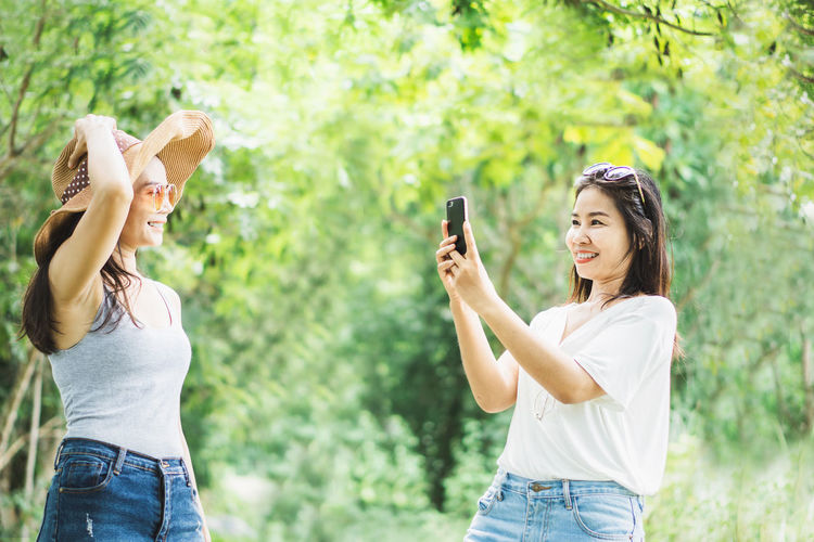 Young woman photographing with mobile phone