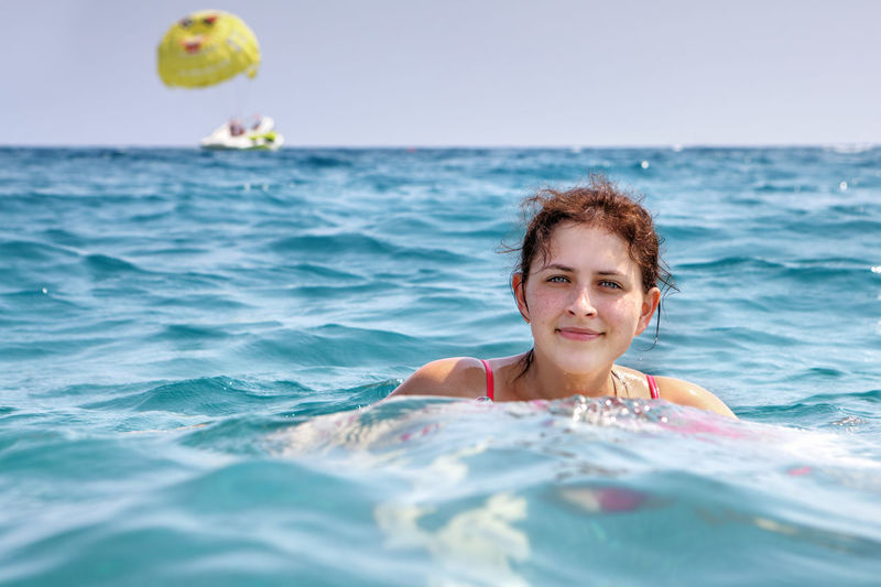 Portrait of woman swimming in sea against clear sky