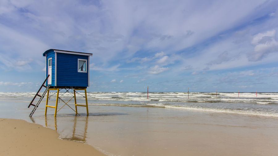 Lifeguard hut on beach against sky