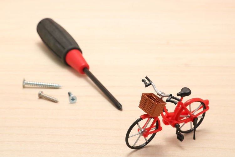 Close-up of bicycle figurine with work tools on table