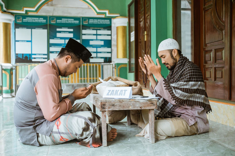 Young men praying together to allah in mosque
