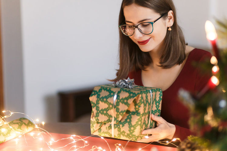 Young millennial woman with christmas presents in a festive atmosphere