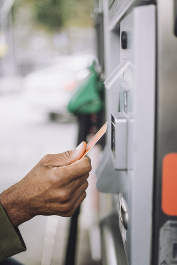 Hand of man doing payment via credit card at gas station