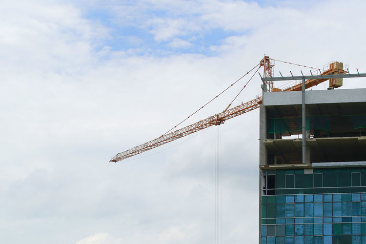 Low angle view of crane against sky