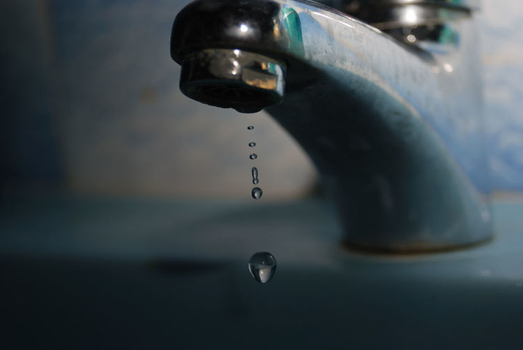 Close-up of water droplet dripping from faucet