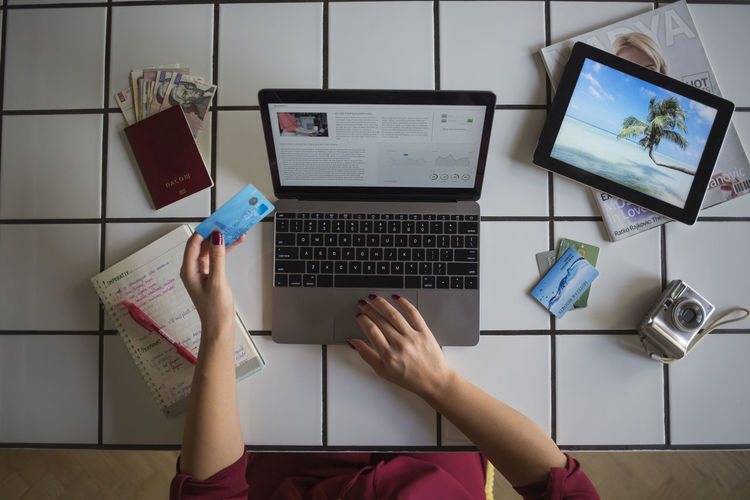 Young woman using laptop, paying with credit card, travel booking