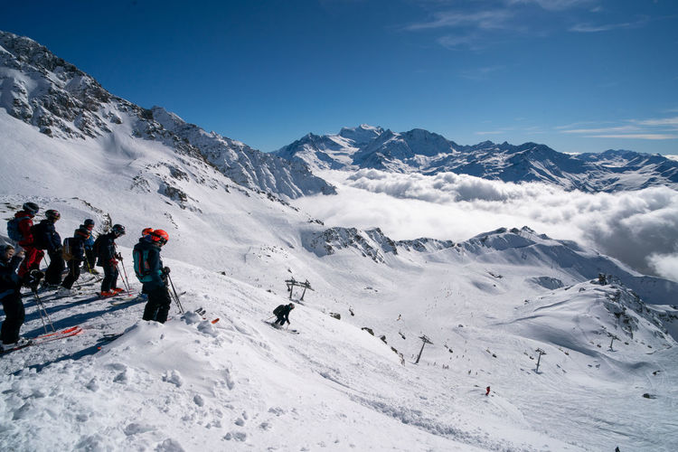 People on off-piste ski school going down the mountain 