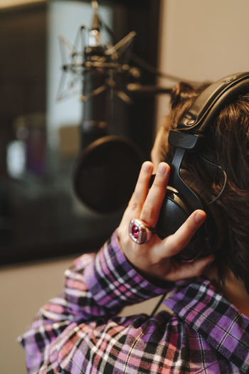 Hand of singer on headphones in studio