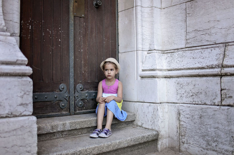 Girl sitting on staircase near door
