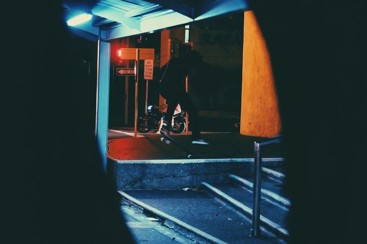 Man with bicycle on illuminated mirror at night