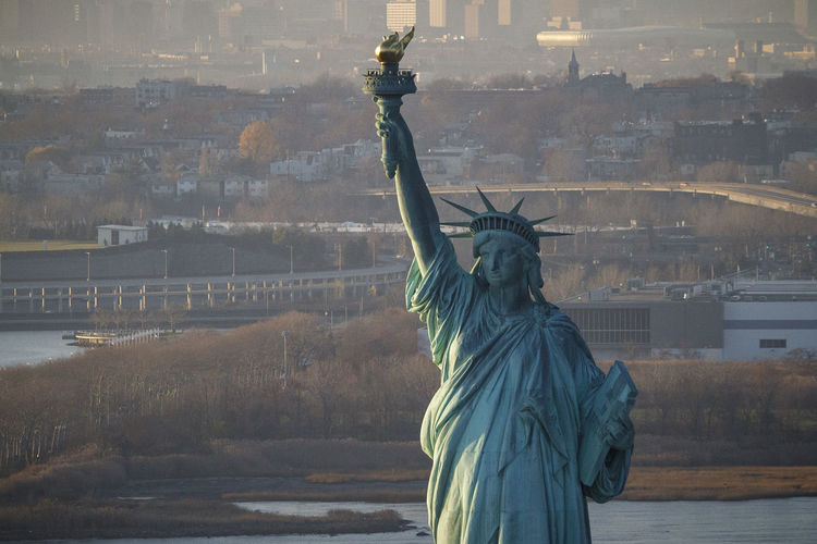 Sunset on the statue of liberty in new york harbor, new york city.