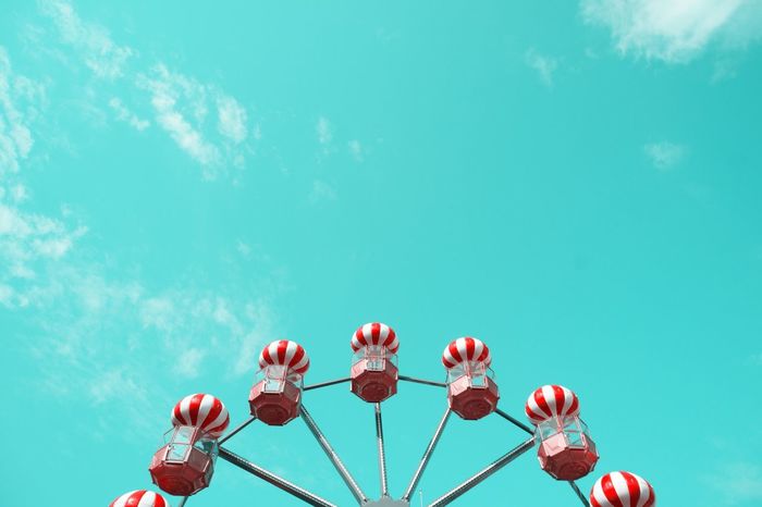 Low angle view of red striped ferris wheel against sky