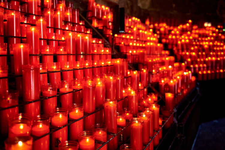 Lit tea light candles on votive stand in santa maria de montserrat