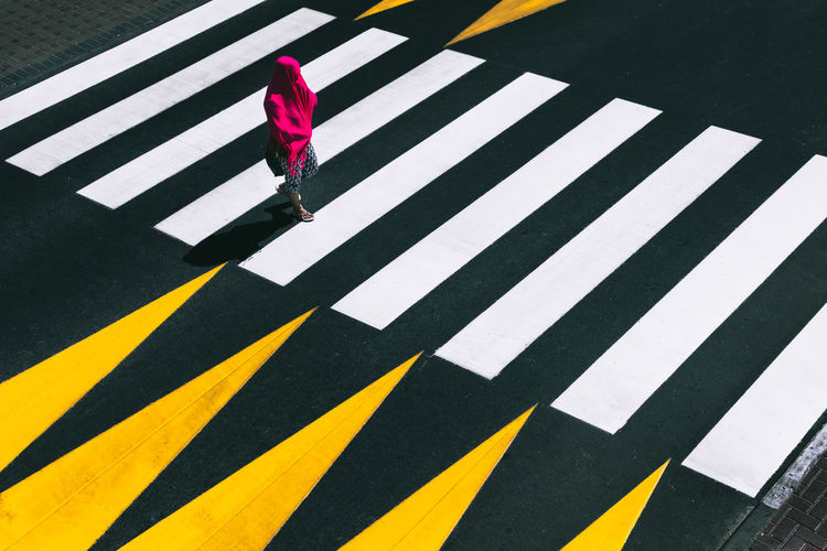 Full length of woman walking on zebra crossing