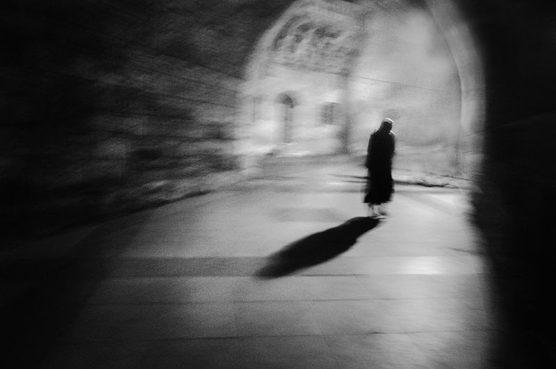 Silhouette person walking on street in city