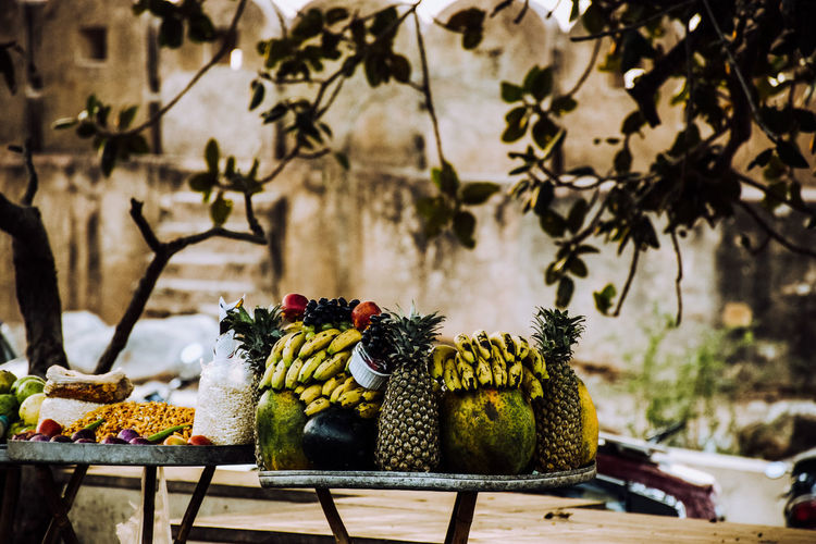 Various fruits on table against trees