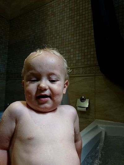Portrait of shirtless boy in bathroom