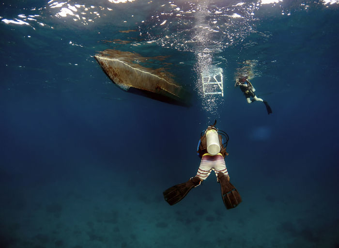 Male friends scuba diving in sea
