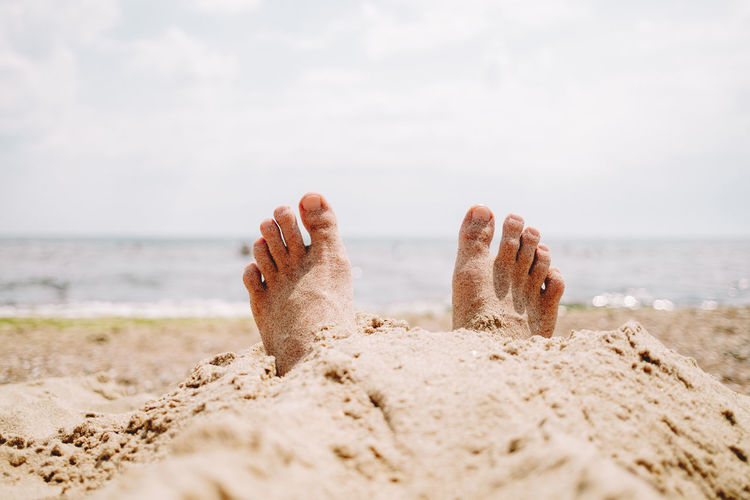 Low section of person relaxing on beach