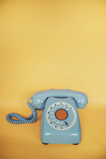 Close-up of telephone on colored background