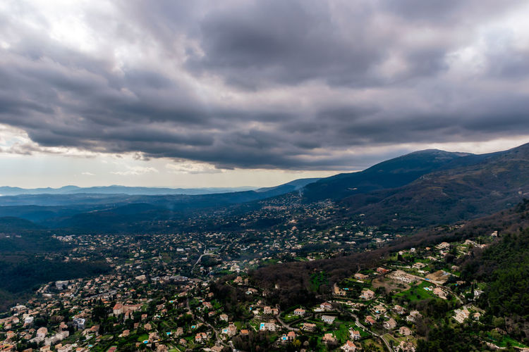 Aerial view of townscape and mountains against sky