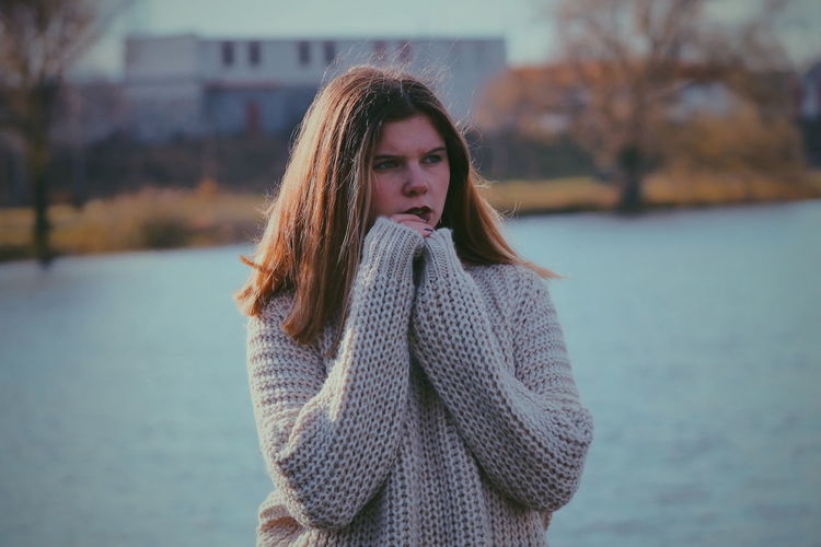 Teenage girl standing against river