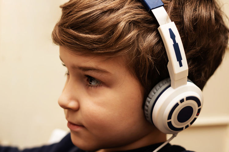 Close-up of kid with headphones at home.