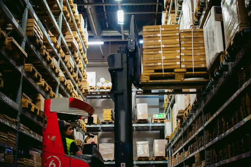 Worker driving forklift in factory