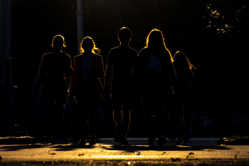 Silhouette people standing on street at night