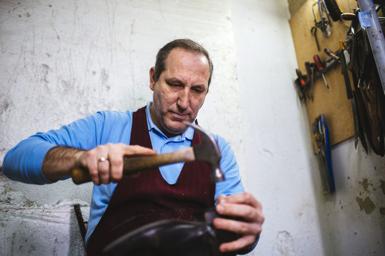 Shoemaker repairing a shoe in his workshop