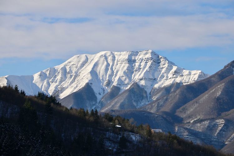 Scenic view of snowcapped corno alle scale mountain against sky on the tuscan emilian apennines