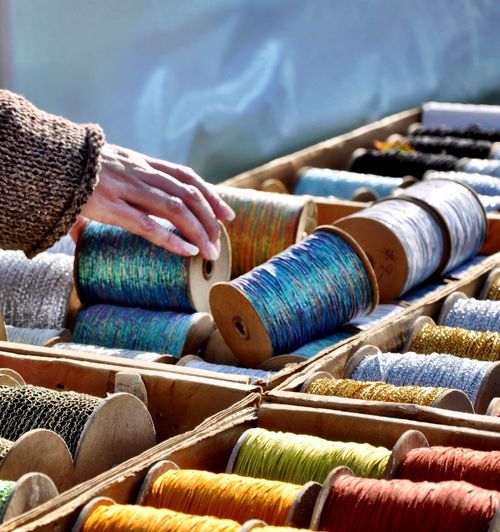 Cropped hand of woman choosing spool in market