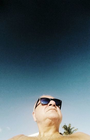 Close-up portrait of man wearing sunglasses against sky