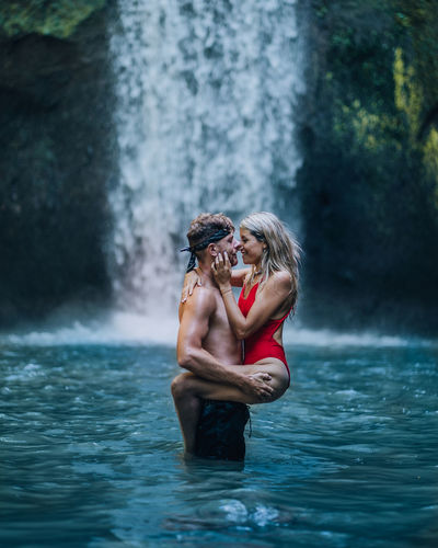A couple at a waterfall in bali.