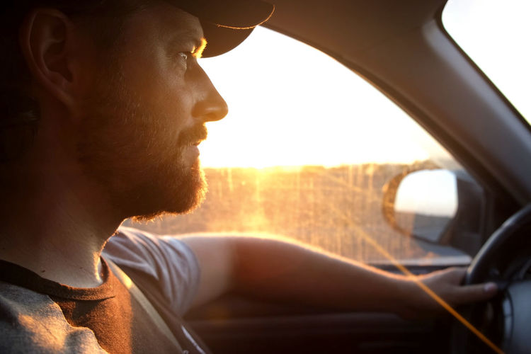 Side view of man looking through window